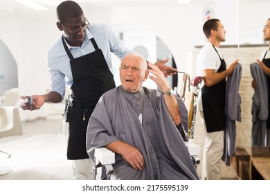 Silver Haired Senior Man Unpleasantly Surprised By Haircut From African-American Hairdresser In Hair Salon