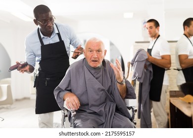 Silver Haired Senior Man Unpleasantly Surprised By Haircut From African-American Hairdresser In Hair Salon