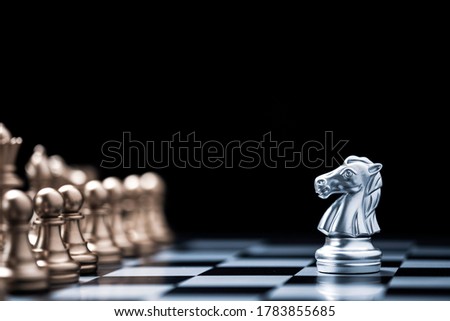 Silver horse chess encounters with gold chess enemy on chess board and black background. Market or business competitor concept.