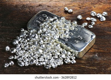 Silver Ingot And Granules On Wooden Background