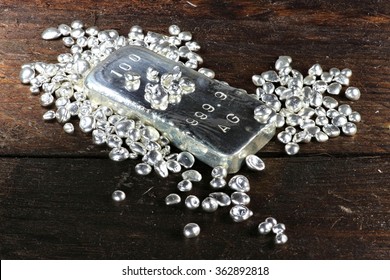 Silver Ingot And Granules On Wooden Background