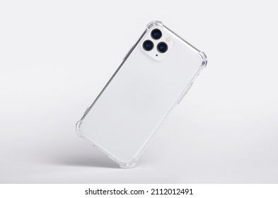 Silver iPhone 11 and 12 Pro max in clear silicone case falls down back view, phone case mockup isolated on gray background - Shutterstock ID 2112012491