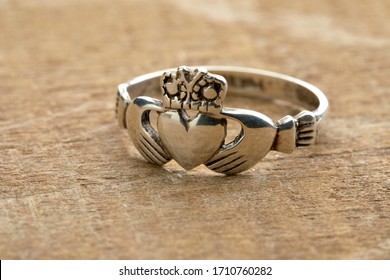 Silver Irish Claddagh ring on wooden background