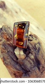 Silver Jewellery With Amber On Old Wood On The Beach.