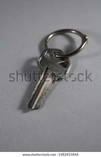 silver key on\
keychain for house car room\
door