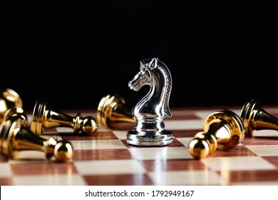 Silver Knight Chess Defeats Gold Pawns On Wooden Chessboard. Intellectual Duel And Tactical Battle In Business. Strategy Planning, Leadership And Teamwork. Checkmate And Winning In Game Concept.