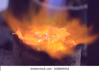 silver material with flame in small crucible, melting process with gas burner.