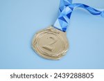 Silver medal with on blue background.