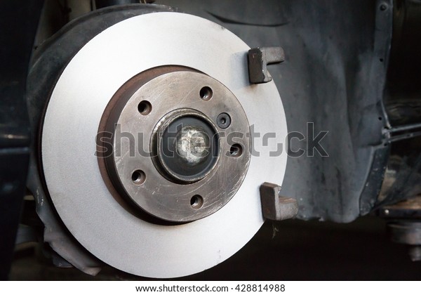 silver metal break disk, break replacement
in garage, maintenance disk break system 

