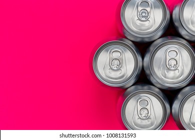 Silver metal energy drinks cans on pink background with copy space
