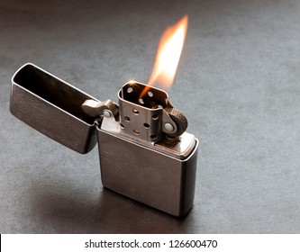 Silver Metal Lighter On Black Background With Flame.