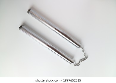 A Silver Metal Nun Chuck On A White Background