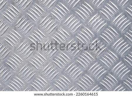 Silver metal panel with checkered crosshatch pattern. Background and wallpaper texture