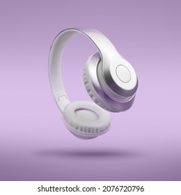 Silver metallic white wireless headphones in the air on Lavendula purple background. Trendy minimal music device flying levitation concept of accessories. New technologies. Closeup high resolution - Shutterstock ID 2076720796