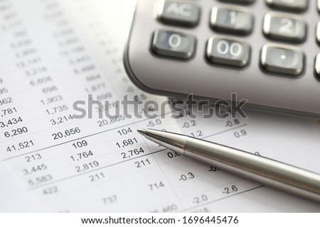 Silver pen lies on report with numbers, calculator. Preliminary analysis target audience. Investor invests in this investment project. Choosing product or new business to enter market