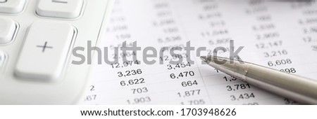 Silver pen report with numbers next to calculator. Range financial instruments for trading on currency exchange. Financial data analysis. Marketing tactics and business lead management