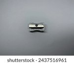 The silver pencil sharpener has a slight stain placed horizontally on a white background, top view