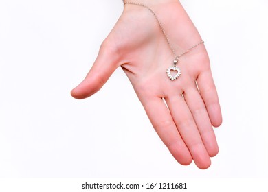 Silver pendant in the shape of a heart on a hand