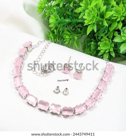 Silver and Pink neckless with greenry background 