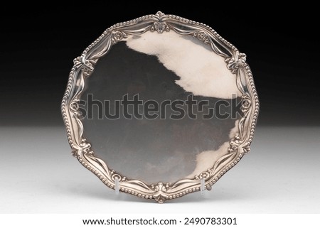 A silver plate tray on a gradient background.