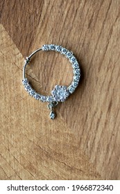 Silver Plated Nose Ring With Diamonds On A Wooden Surface