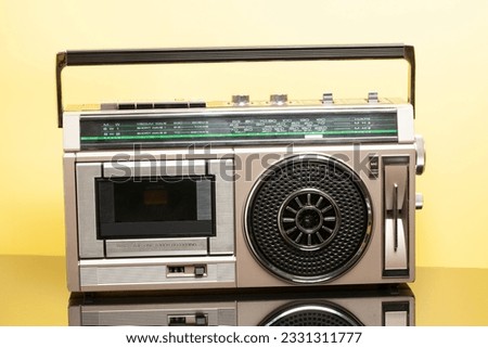 Silver retro ghetto radio boom box cassette recorder from 80s. on a yellow background