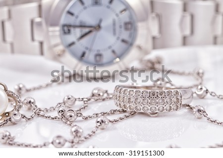 Silver ring and chain on the background of women's watches