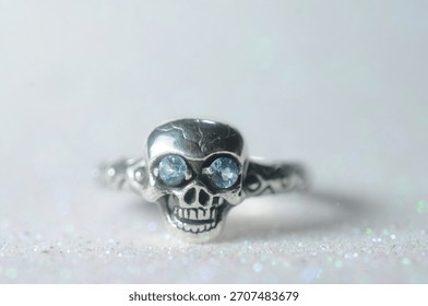 silver ring in the shape of a skull head with gemstones in its eyes