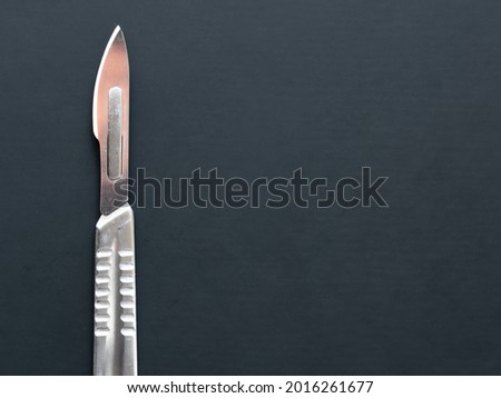 Silver scalpel on black background