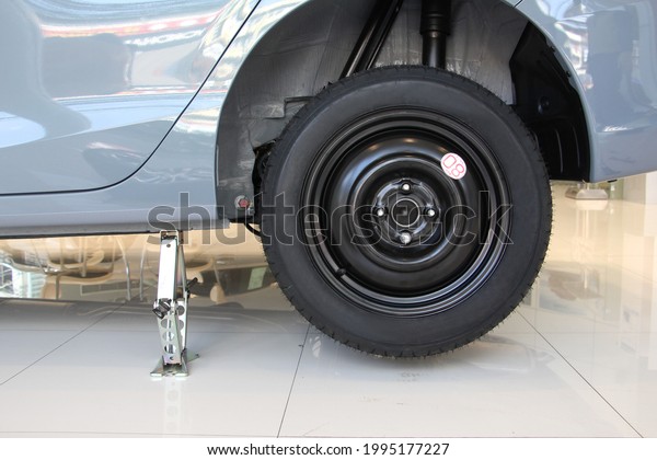 Silver scissor Car\
jacked up the body car with spare wheel. Car jack is tools of\
change a spare wheel or tires. Car repair or Accident between\
travel or vehicle\
concept.