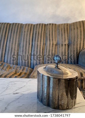 Silver seashell on marble table and stripe sofa
