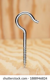 Silver Shepherd Hook Screwing Standing On Plywood Background