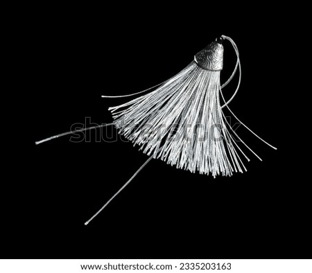 Silver Silk Tassel for decorating. Indian culture hang Tassel for moving wind blow and elegance look. Tassel has many color spinning in air. Black background isolated freeze motion