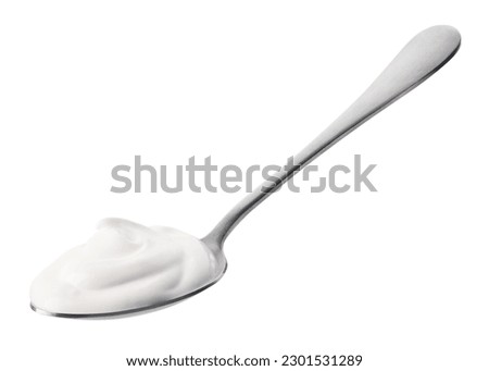 Silver spoon of fresh greek yogurt isolated on white background