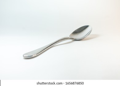 Silver spoon lies on a white background - Shutterstock ID 1656876850