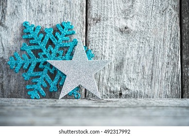 Silver Star And Blue Snowflake On Rustic Wood Background. Merry Christmas Card. Winter Holiday Theme. Happy New Year. Space For Text.