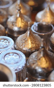 Silver tea sets glimmer, featuring intricate designs and patterns.