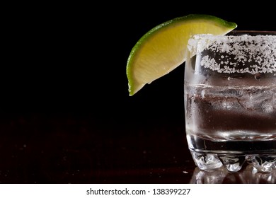 Silver Tequila Shot Served On The Rocks In A Small Glass With A Lime Wedge And Salt On The Rim