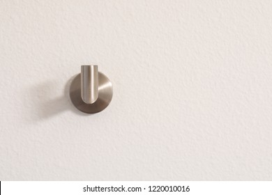 Silver towel hook on a white wall