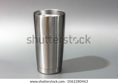 
Silver tumbler glass cold store.
Stainless steel thermos tumbler mug on gray  background.