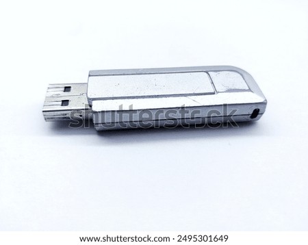 The silver USB 2 flash disk, 2 gigabytes in size, is more than five years old and can still be used. This photo was taken on white paper and has high resolution. 
