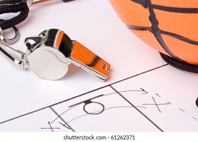 A Silver Whistle Laying Next To An Orange Basketball And The Drawing Of A Game Plan.