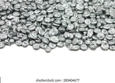 Silver zinc granules on a white background