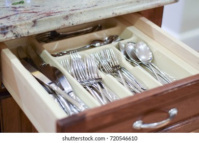 Silverware (forks, knives, spoons) in a drawer in a kitchen - Shutterstock ID 720546610