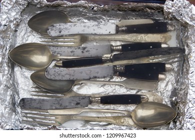 Silverware in a salt bath with aluminium foil to clean it from stains and making it shiny again. Old fashioned way of cleaning precious silverware