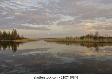 silvery clouds at sunset reflected in the river