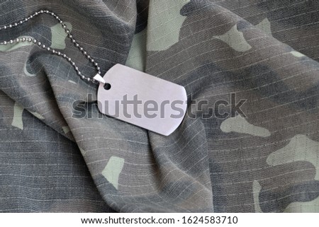 Silvery military beads with dog tag on camouflage fatigue uniform