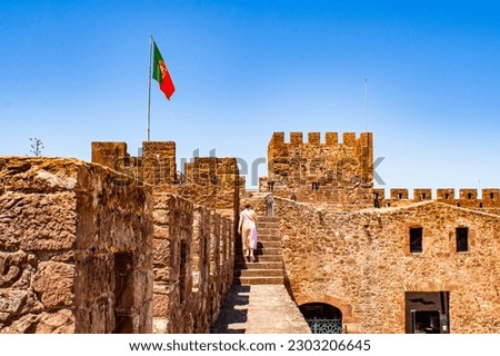 Silves castle in the South of Portugal with a woman ascending the staircase of the ramparts on a sunny day