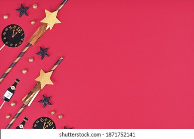 Silvester celebration flat lay with golden, black and white striped paper stars and Champaign flute and clock paper decoration on pink background with copy space 