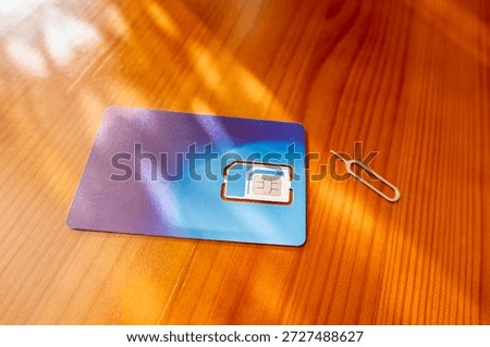 Sim Card and Eject Pin. sim card on desk, close-up